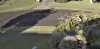 Image of Axis M31 camera. Scene is lawn, footpath, tree and road. Wide Dynamic range is on. Main area is darker than bright area with sunshine. Area with sunshine is compensated for, you can see detail in bright and dim area.